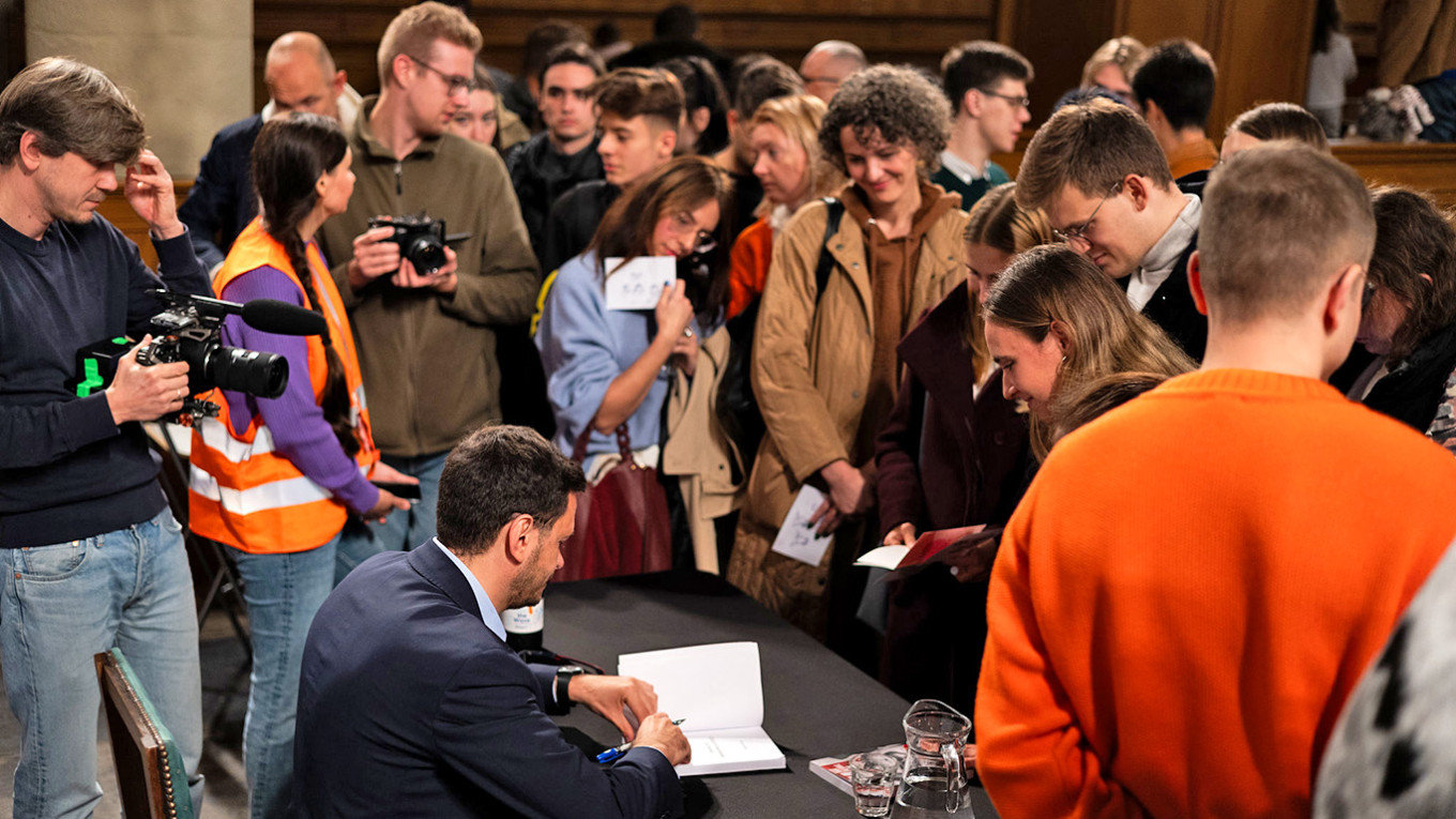 Ilya Yashin signing books at De Waalse Kerk, Amsterdam. Aleksandr Vasiliukha